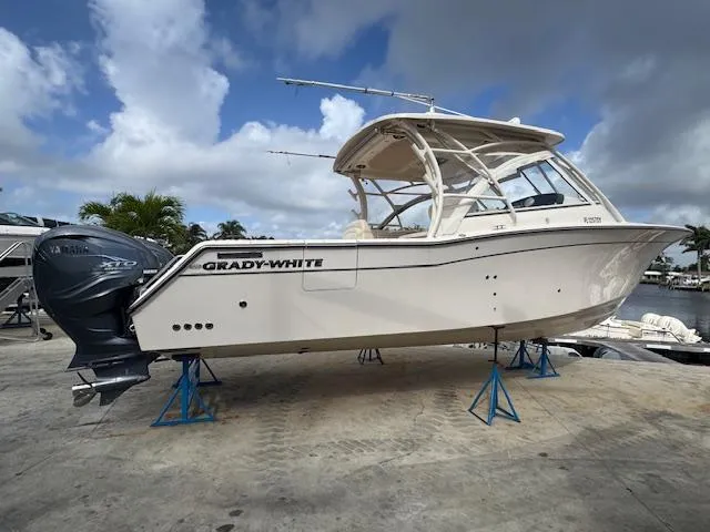 Slide: The Image of 2021 Grady-White Freedom 335 boat on stands, showcasing sleek design and powerful engines. - 5