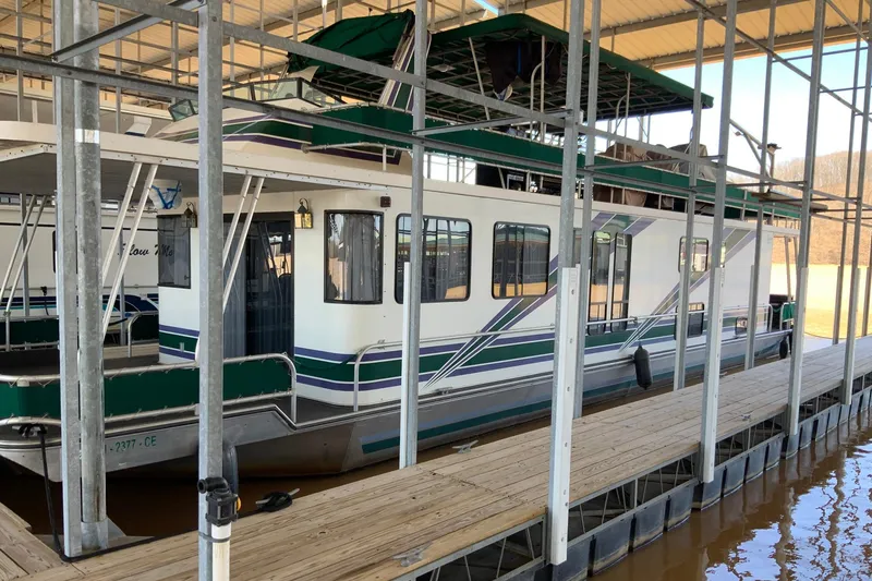 The Image of 1997 Lakeview 16 x 65 houseboat docked in a covered marina. - 0