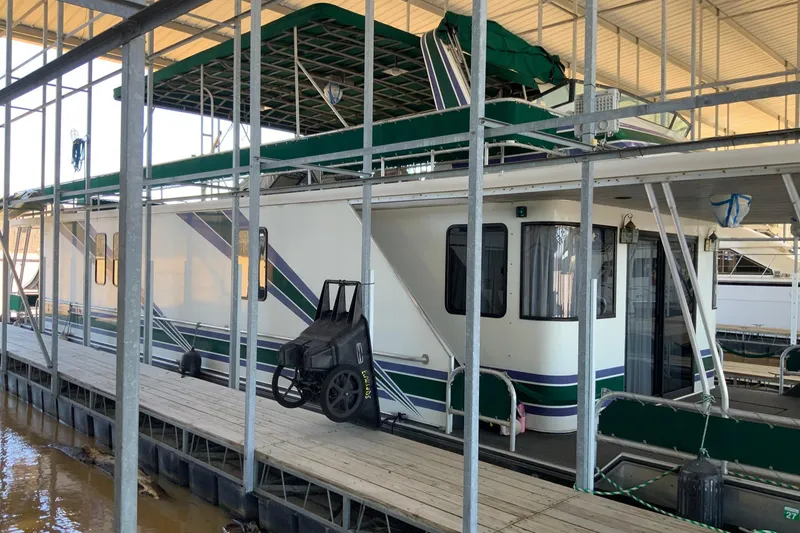 Slide: The Image of 1997 Lakeview 16 x 65 houseboat docked under a covered marina. - 1