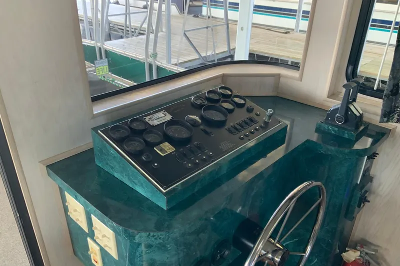 Slide: The Image of Control panel of a 1997 Lakeview 16 x 65 houseboat with steering wheel and gauges. - 12