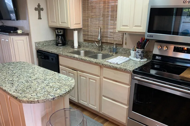 Slide: The Image of Modern kitchen in 1997 Lakeview 16 x 65 houseboat with granite countertops and stainless steel appliances. - 16