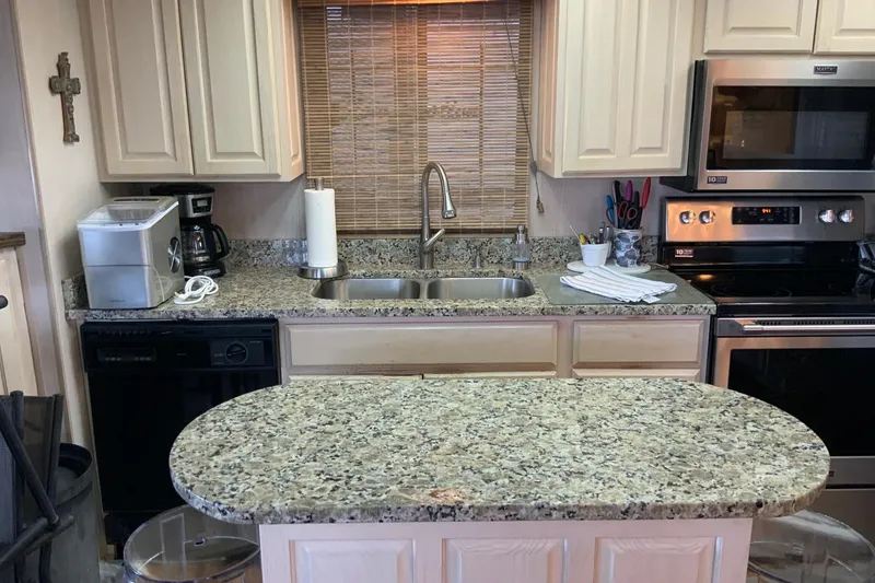 Slide: The Image of Modern kitchen with granite countertops, stainless steel appliances, and beige cabinets in a 1997 Lakeview model. - 18