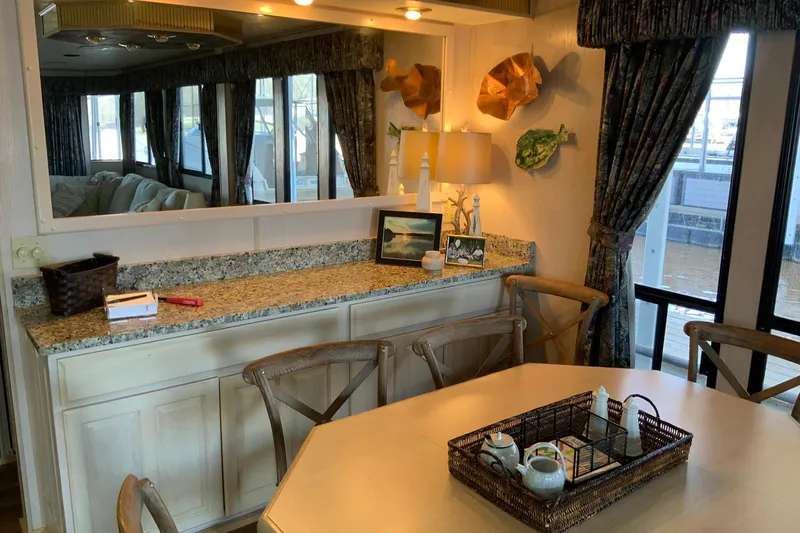 Slide: The Image of Dining area in a 1997 Lakeview houseboat with wooden chairs and decorative elements. - 19