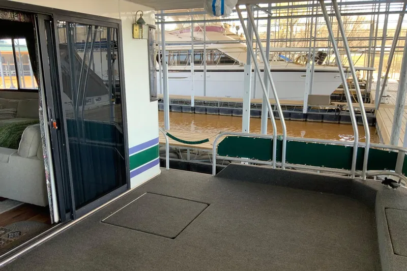 Slide: The Image of 1997 Lakeview 16 x 65 houseboat interior with dock view, featuring sliding glass door. - 2