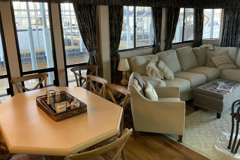Slide: The Image of Cozy living area in 1997 Lakeview houseboat with sofa, dining table, and large windows. - 21