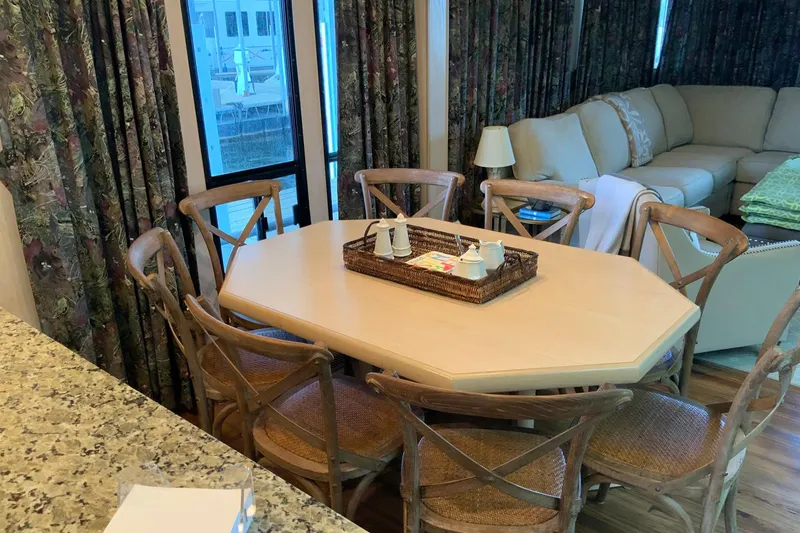 Slide: The Image of Dining area in 1997 Lakeview houseboat with wooden chairs and a cozy living space. - 22