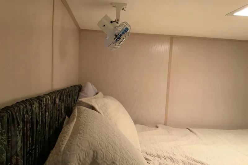 Slide: The Image of Cozy bedroom in 1997 Lakeview 16 x 65 houseboat with wall-mounted fan. - 25