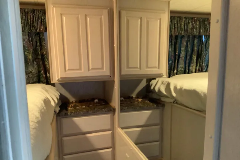 Slide: The Image of Interior of 1997 Lakeview 16 x 65 houseboat with mirrored cabinets and cozy bedding. - 26