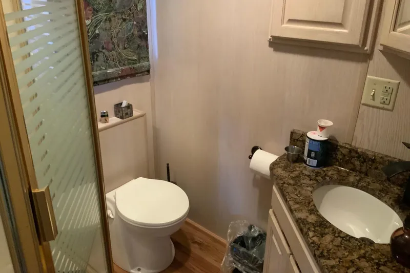 Slide: The Image of Small bathroom with granite countertop, shower, and toilet in a 1997 Lakeview 16 x 65 model. - 27