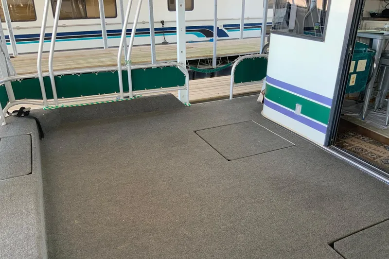 Slide: The Image of 1997 Lakeview 16 x 65 houseboat deck with carpet and railing, open door to interior. - 3