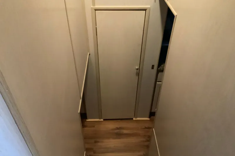 Slide: The Image of Narrow hallway with wooden flooring and a closed door, Lakeview 16 x 65, 1997 model. - 31