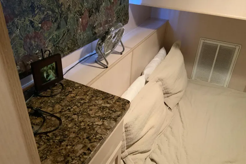 Slide: The Image of Cozy bedroom in 1997 Lakeview 16 x 65 houseboat with granite countertop and fan. - 34