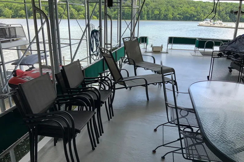 Slide: The Image of Spacious deck of 1997 Lakeview houseboat with chairs, overlooking serene lake view. - 4