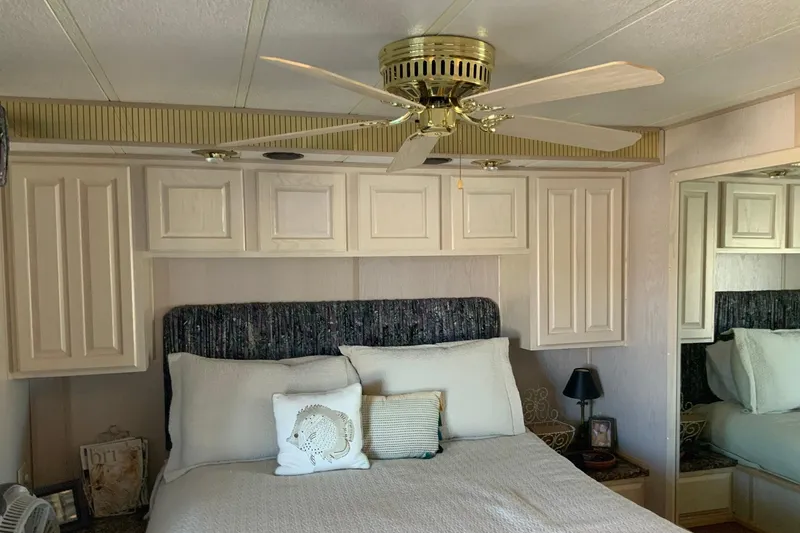 Slide: The Image of Bedroom interior with ceiling fan, bed, and cabinets in a 1997 Lakeview 16 x 65 model. - 40