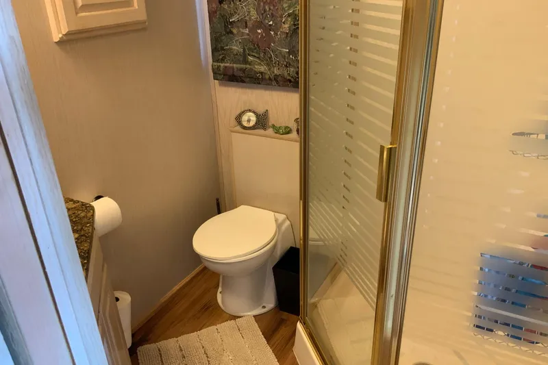 Slide: The Image of Compact bathroom with shower, toilet, and wooden flooring in a 1997 Lakeview 16 x 65 model. - 44