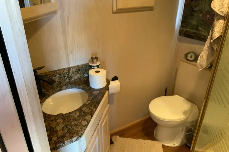 Slide: The Image of Small bathroom with granite countertop, sink, toilet, and shower in a 1997 Lakeview 16 x 65 model. - 45