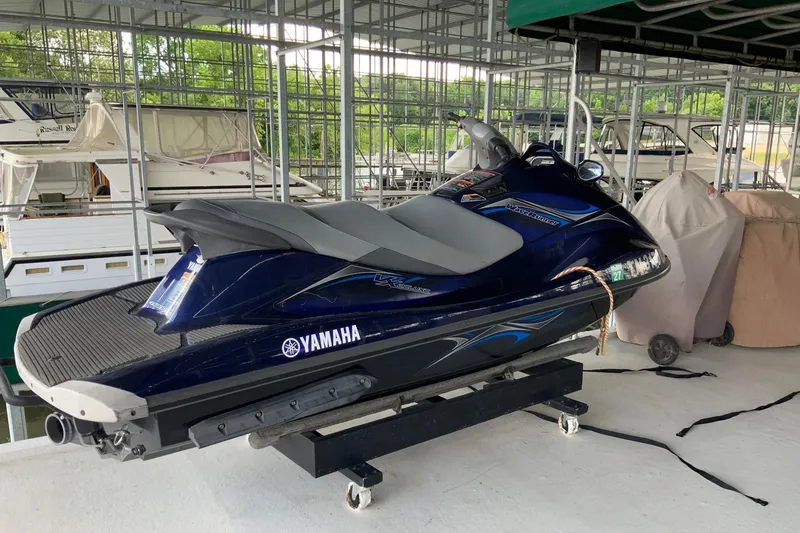 Slide: The Image of A Yamaha jet ski on a dock, surrounded by covered boats. - 8