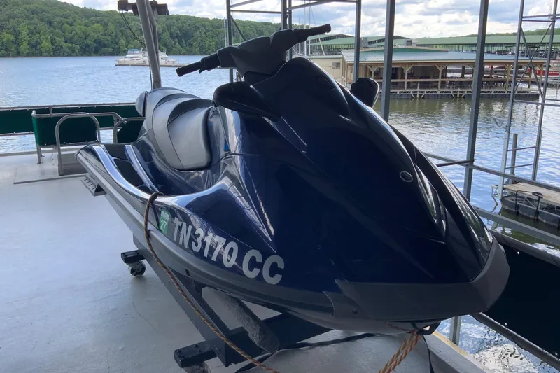 Slide: The Image of Blue jet ski docked on a Lakeview 16 x 65 houseboat, 1997 model, by a scenic lake. - 9