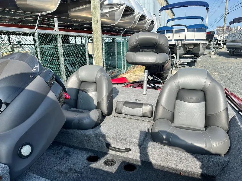 Slide: The Image of 2019 Tracker TXW175 Tournament Edition boat with gray seating and console, parked outdoors. - 6