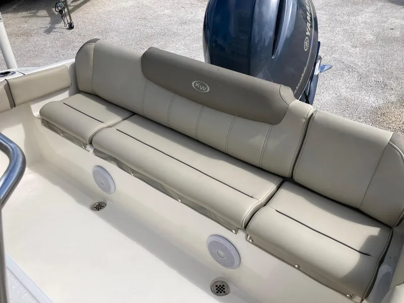 Slide: The Image of 2022 Key West 219fs boat with beige cushioned seating and Yamaha engine. - 19