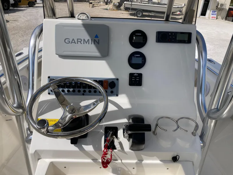 Slide: The Image of 2022 Key West 219fs boat console with Garmin navigation, steering wheel, and control panel. - 8