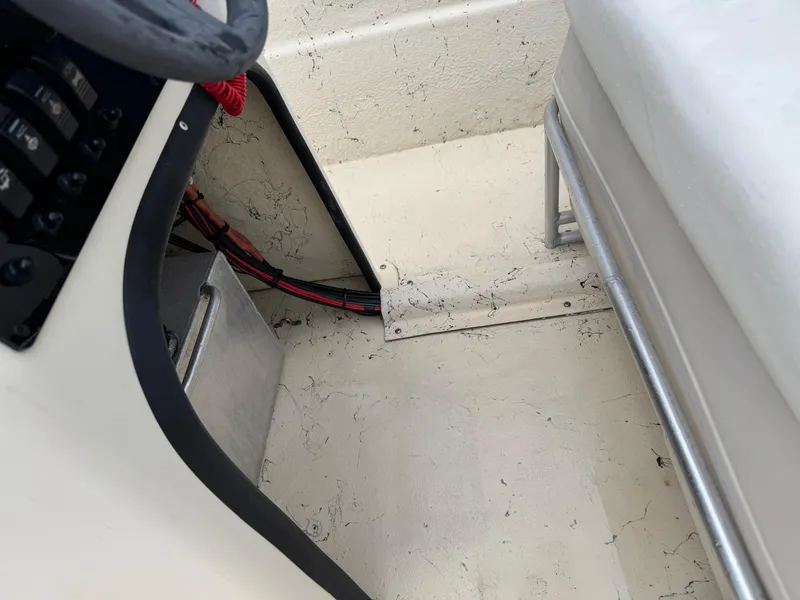 Slide: The Image of 2001 Carolina Skiff 17 Center Console interior with new Suzuki 40HP engine, showing steering and seating area. - 2