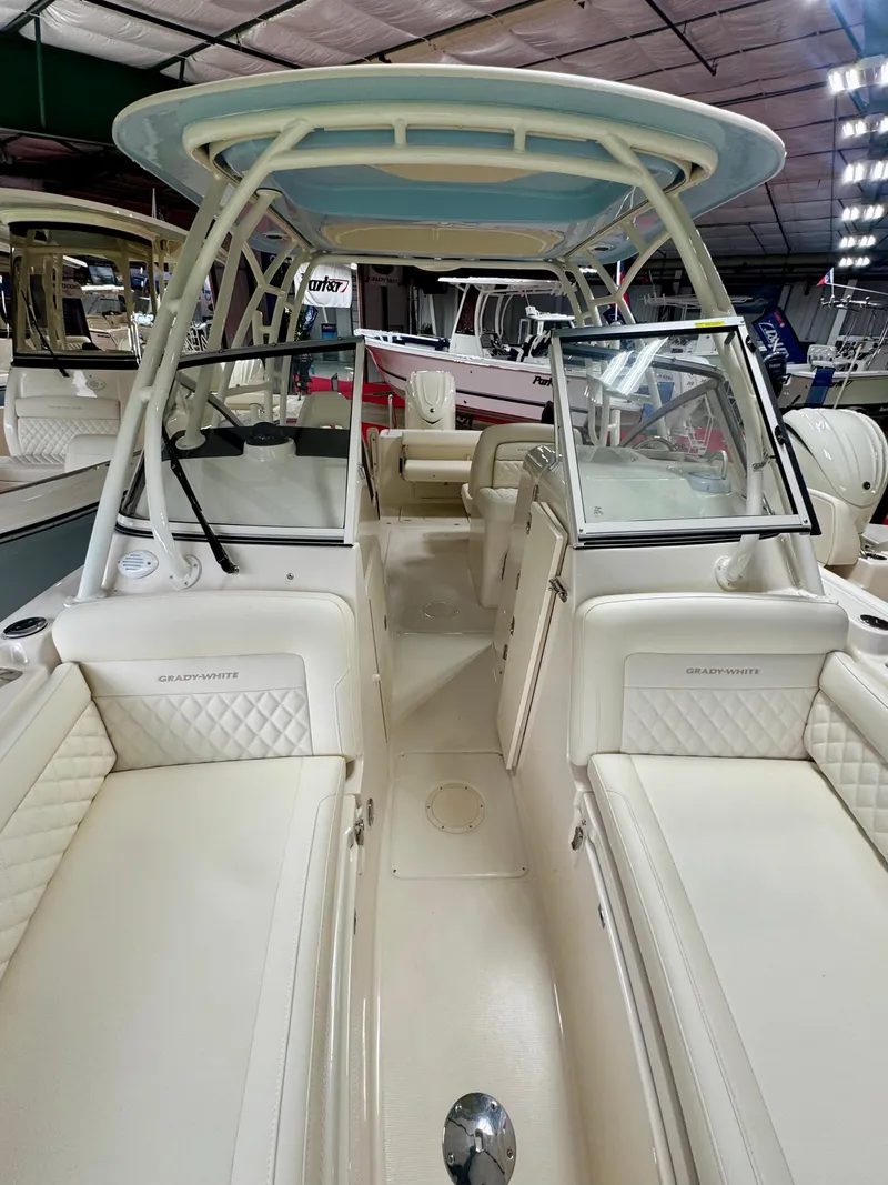 Slide: The Image of 2025 Grady-White Freedom 235 boat interior with seating and helm, displayed indoors. - 14