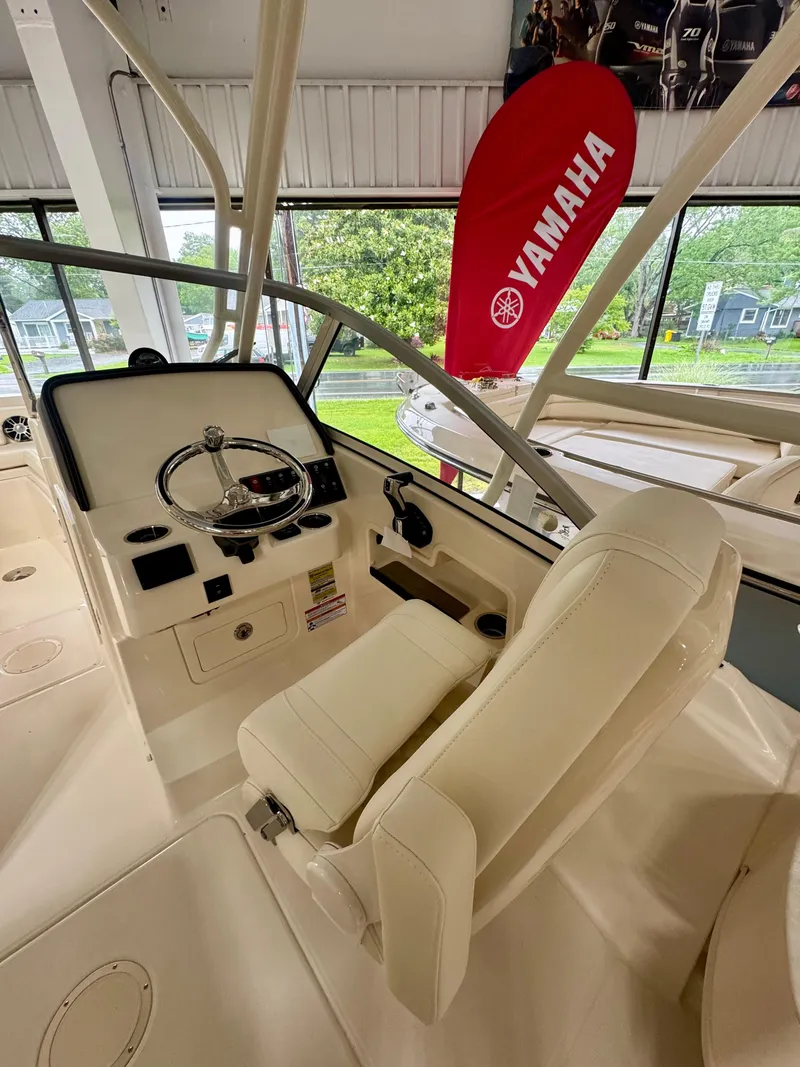 Slide: The Image of 2025 Grady-White Freedom 235 boat interior with steering wheel and Yamaha banner. - 9