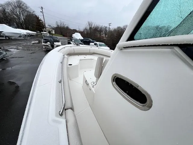 Slide: The Image of 2016 Boston Whaler 250 Outrage boat, docked on a rainy day, showcasing sleek design. - 13