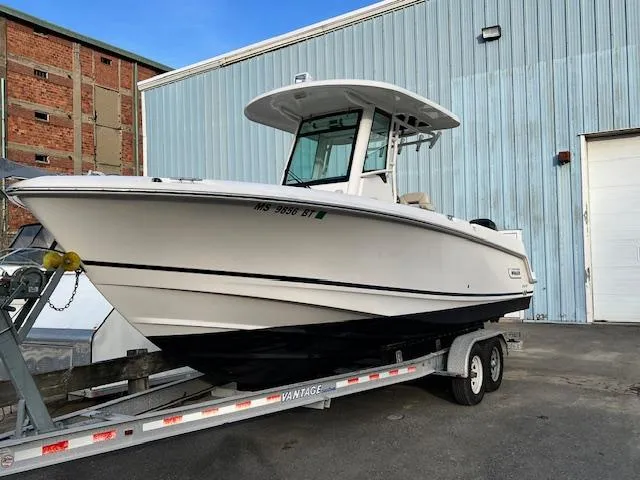 Slide: The Image of 2016 Boston Whaler 250 Outrage boat on trailer, parked near industrial building. - 3