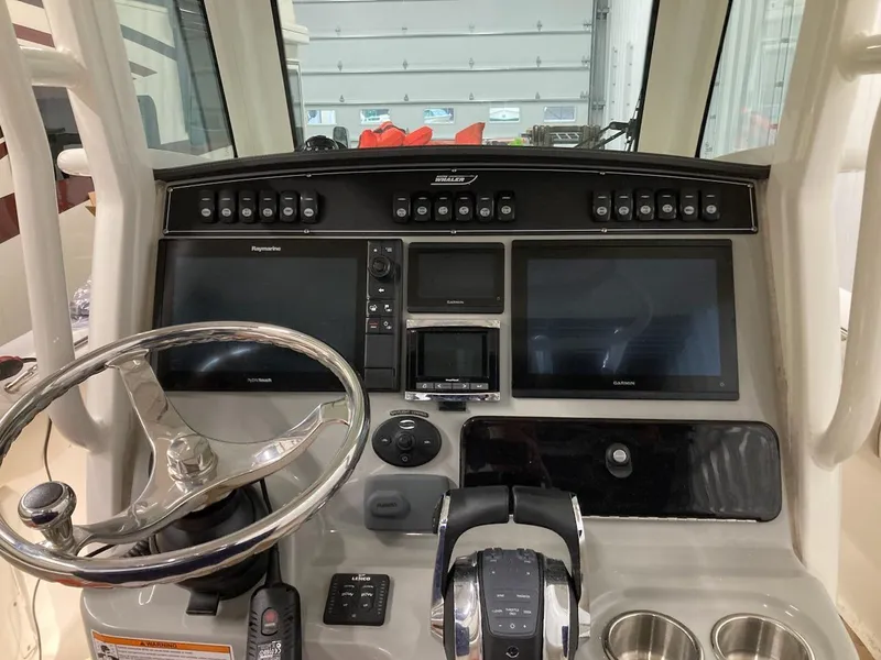 Slide: The Image of Control panel of a 2016 Boston Whaler 250 Outrage boat with steering wheel and navigation screens. - 7