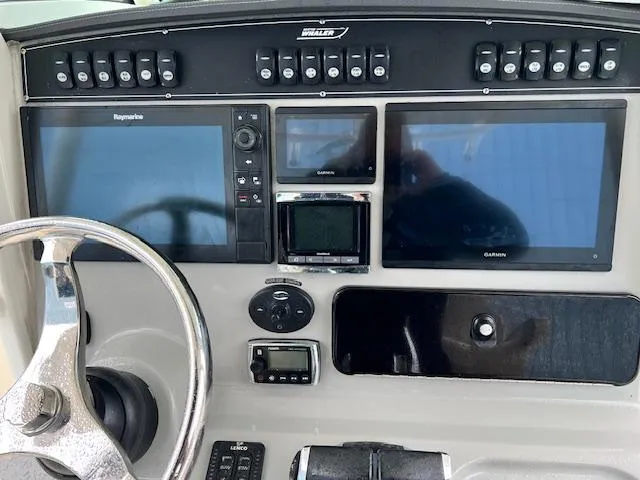 Slide: The Image of Control panel of a 2016 Boston Whaler 250 Outrage with multiple navigation screens and controls. - 8