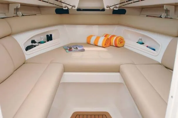 Slide: The Image of 2008 Boston Whaler 320 Outrage Cuddy Cabin interior with beige seating and storage compartments. - 12