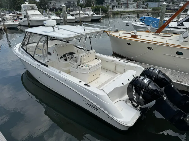 Slide: The Image of 2008 Boston Whaler 320 Outrage Cuddy Cabin docked, featuring twin Mercury engines. - 2