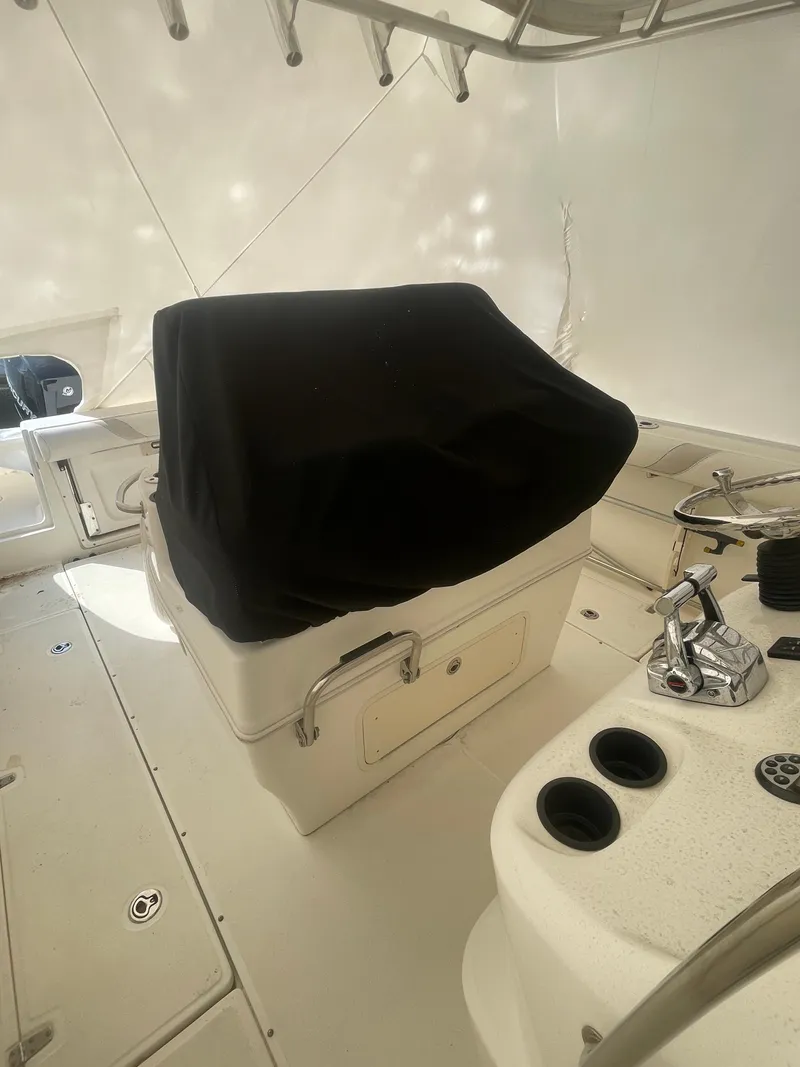Slide: The Image of 2008 Boston Whaler 320 Outrage Cuddy Cabin interior with covered seating and control panel. - 8