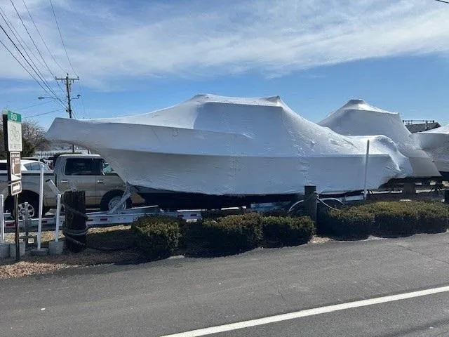 Slide: The Image of 2024 Parker 2520 XLD Sport Cabin boat covered in protective wrap on a trailer. - 13