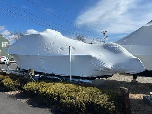 Slide: The Image of 2024 Parker 2520 XLD Sport Cabin boat covered in protective wrap, parked outdoors. - 14