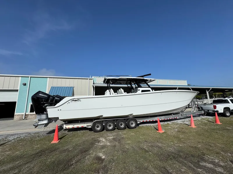 Slide: The Image of 2025 Invincible 46 Catamaran on trailer, parked outdoors near a building. - 11