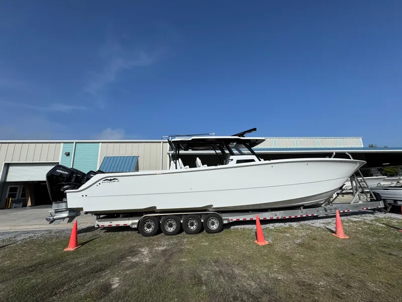 Slide: The Image of 2025 Invincible 46 Catamaran on trailer, parked outdoors, clear sky background. - 12