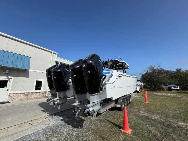 Slide: The Image of 2025 Invincible 46 Catamaran with powerful engines, parked outdoors near a building. - 15