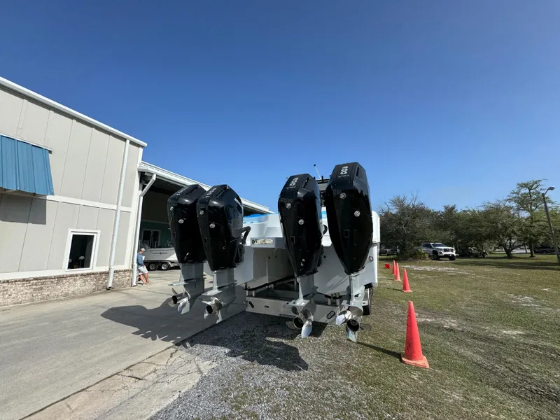 Slide: The Image of 2025 Invincible 46 Catamaran with four powerful outboard engines, parked near a building. - 16