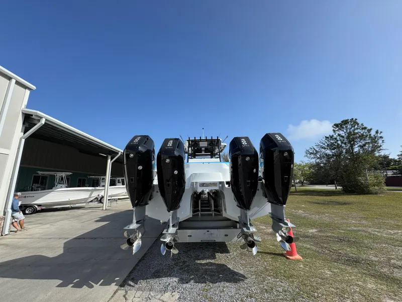 Slide: The Image of 2025 Invincible 46 Catamaran with four powerful outboard engines, parked outdoors. - 17