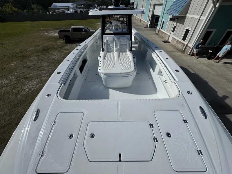 Slide: The Image of 2025 Invincible 46 Catamaran with spacious deck and modern design, docked near buildings. - 18