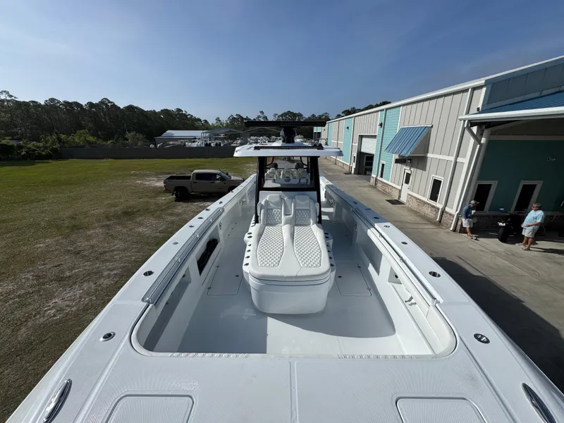 Slide: The Image of 2025 Invincible 46 Catamaran docked near industrial buildings under clear sky. - 19