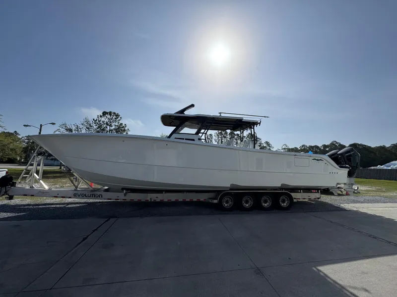 Slide: The Image of 2025 Invincible 46 Catamaran on trailer under bright sun. - 2