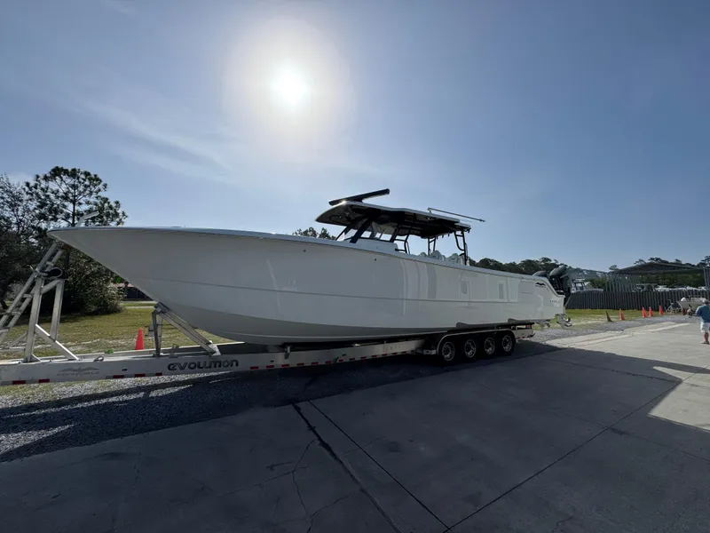 Slide: The Image of 2025 Invincible 46 Catamaran on trailer under bright sun. - 3