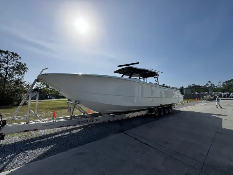 Slide: The Image of 2025 Invincible 46 Catamaran on trailer under bright sun, parked outdoors. - 4