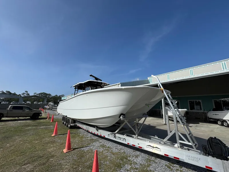 Slide: The Image of 2025 Invincible 46 Catamaran on trailer, parked outdoors under clear blue sky. - 7