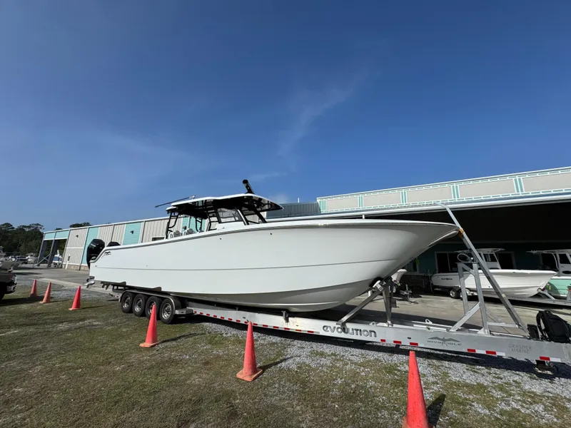 Slide: The Image of 2025 Invincible 46 Catamaran on trailer, parked outdoors with orange cones. - 8