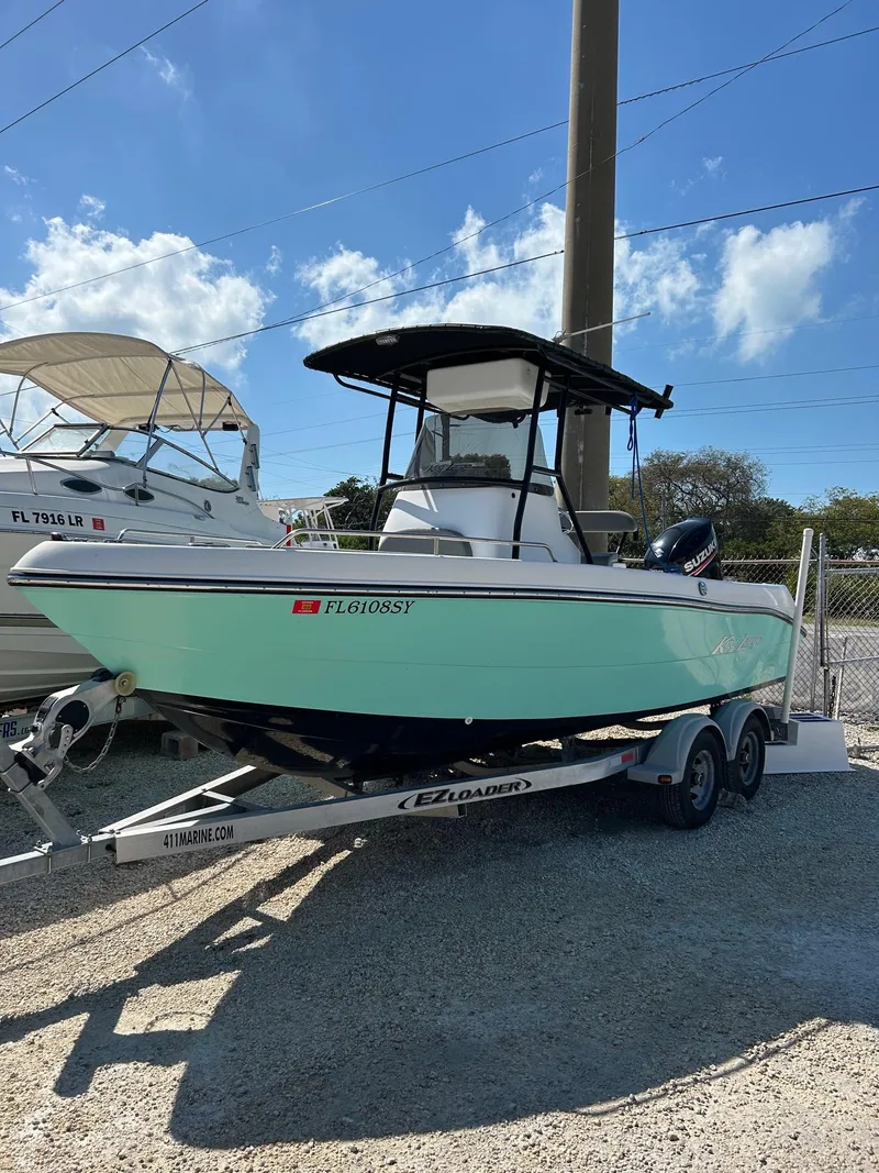 The Image of 2018 Key Largo 210 boat on trailer, parked outdoors under a clear blue sky. - 0